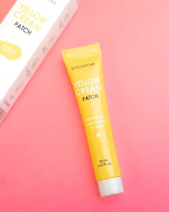 Kocostar Yellow cream patch tube on a pink background, with packaging partially visible, labeled for spot treatment.