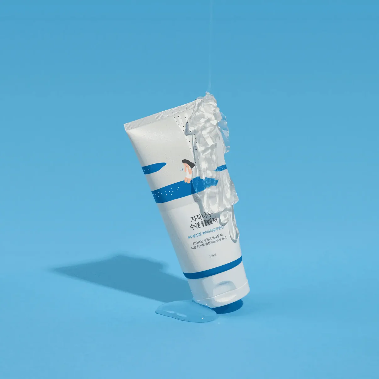A tube of birch moisturizing cleanser with gel dripping, set against a blue background.