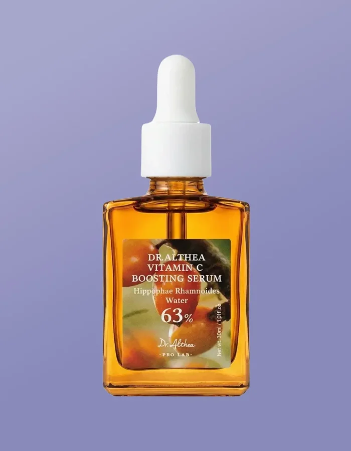 Amber glass bottle of Dr. Althea Vitamin C Boosting Serum with a dropper, set against a light purple background.
