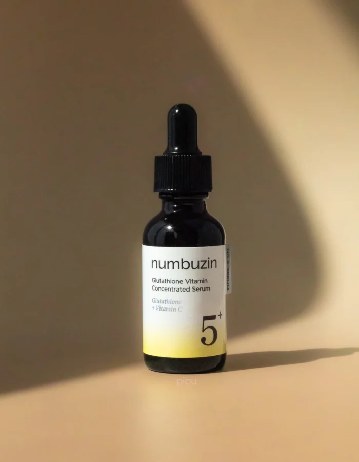 A black dropper bottle of Numbuzin Glutathione Vitamin Concentrated Serum against a soft beige background.