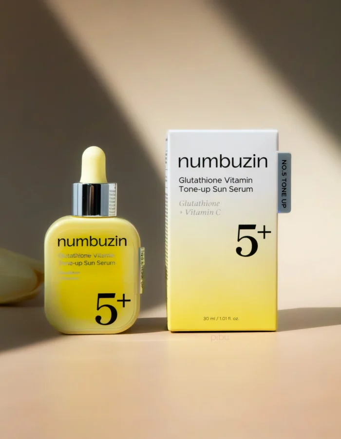 A yellow serum bottle and its box, labeled Numbuzin Glutathione Vitamin Tone-up Sun Serum, on a soft background.