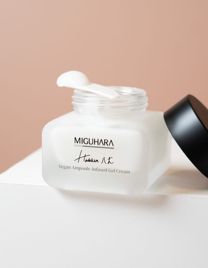 Bottle of 50ml Vegan Ampoule-Infused Gel Cream with open lid and spatula with cream on top